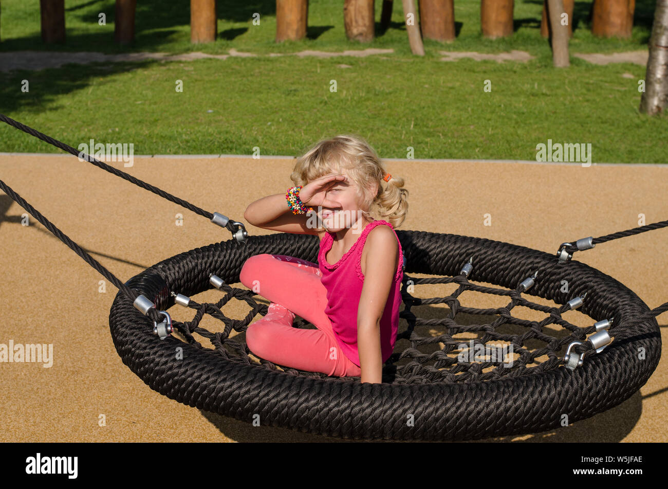 beautiful blond girl playing on playground Stock Photo