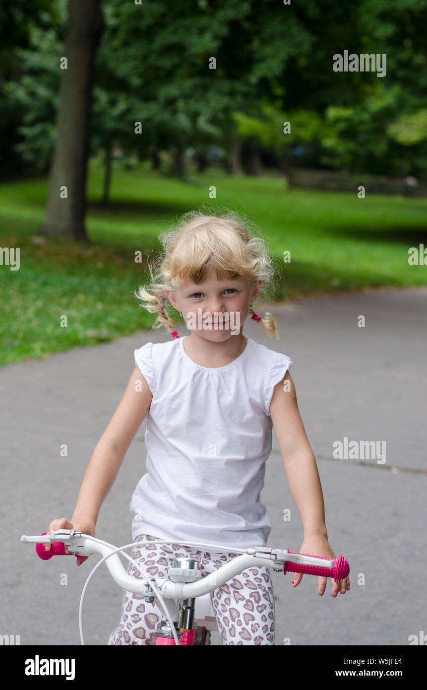 beautiful blond girls sitting on bicycle Stock Photo