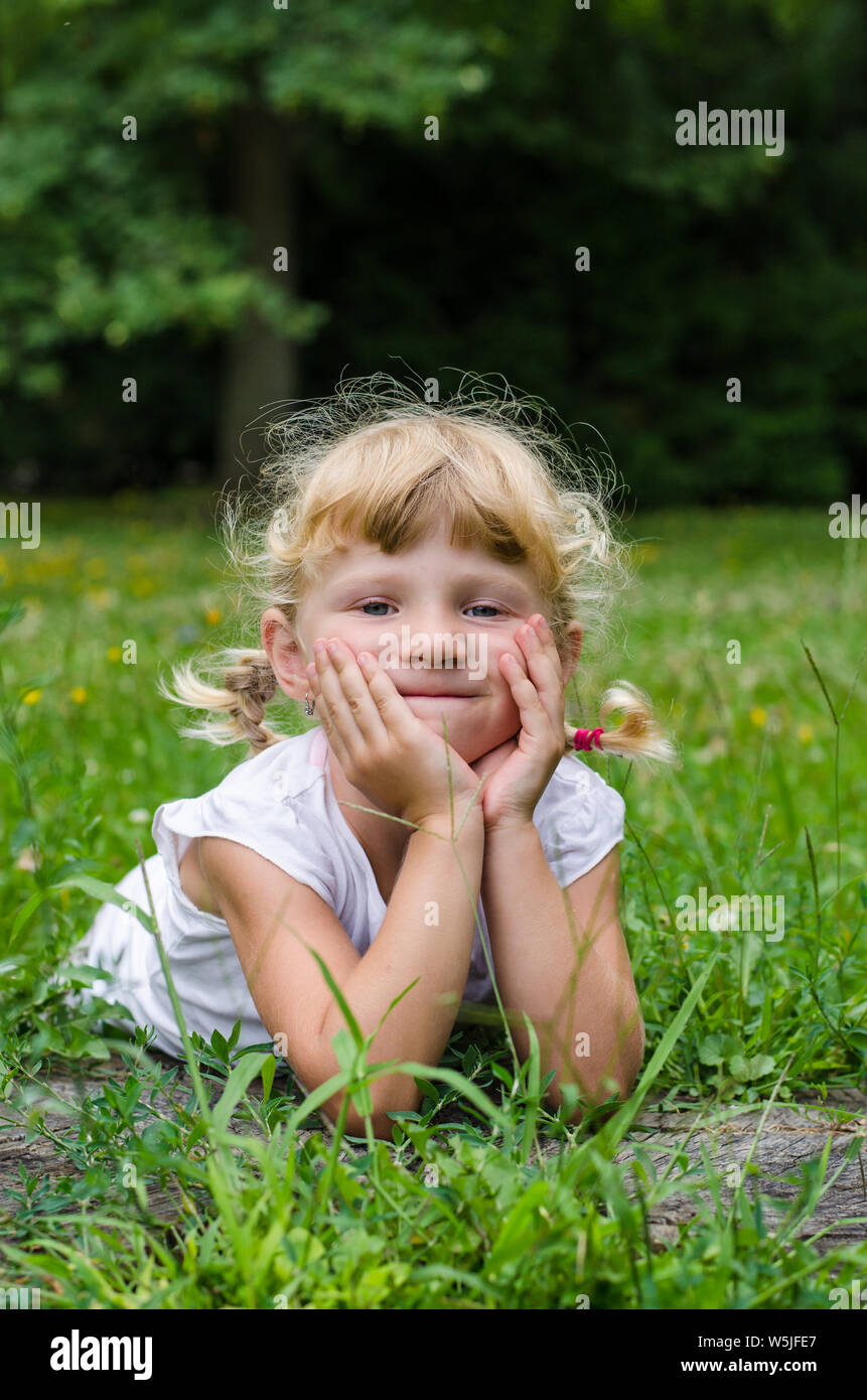 beautiful blond girl lying on meadow Stock Photo