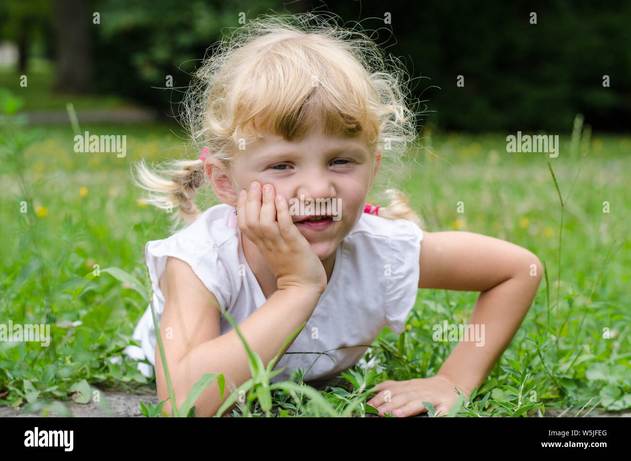 beautiful blond girl lying on meadow Stock Photo