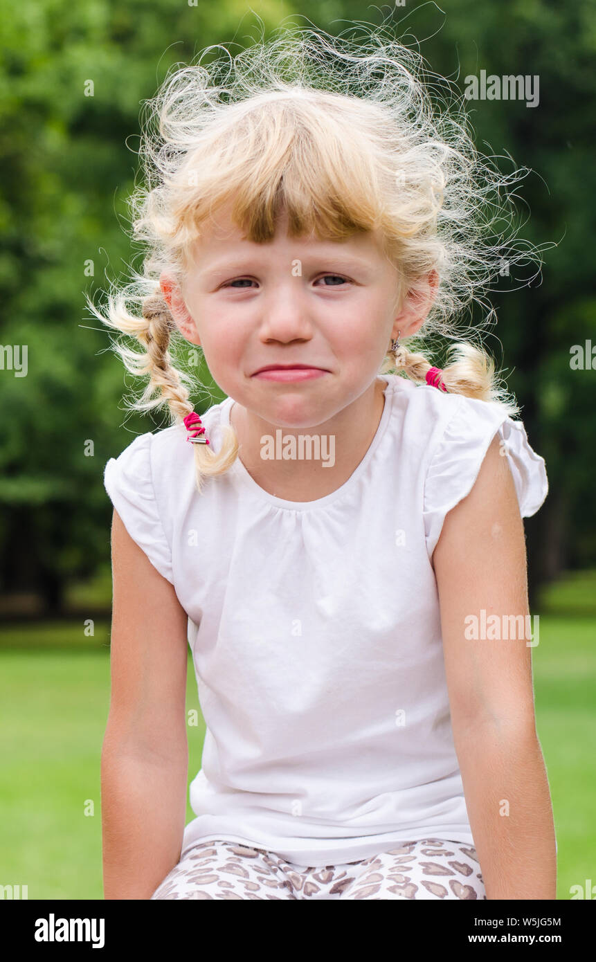 beautiful blond girls sitting on green grass Stock Photo