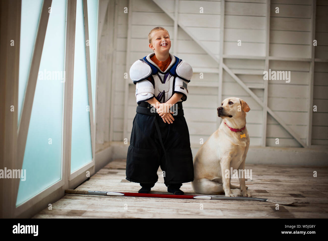 Portrait of young boy dressed up in an oversized hockey uniform. Stock Photo
