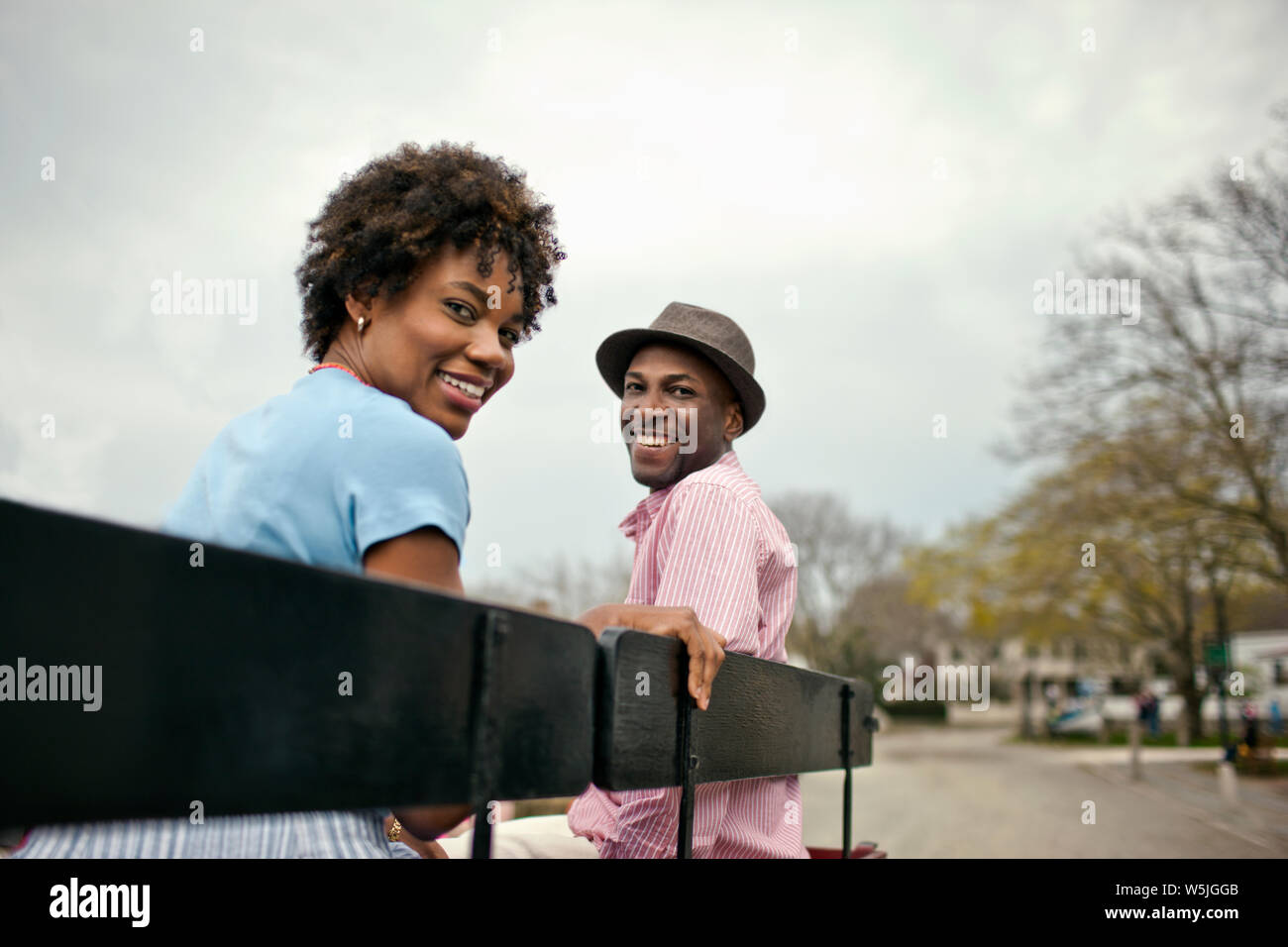 Couple sitting on park bench Stock Photo - Alamy