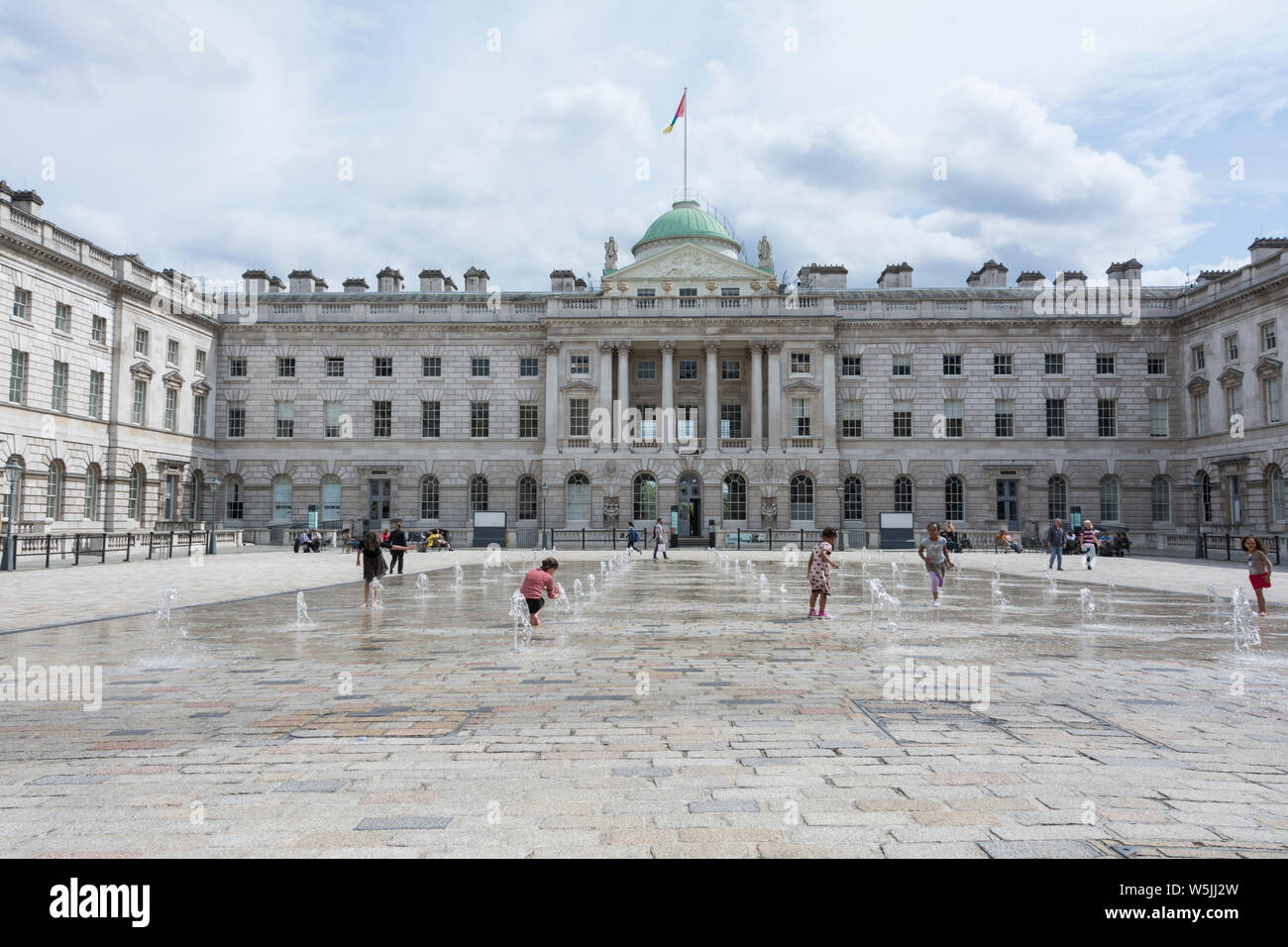Children playing in the water fountains in the  neoclassical Somerset House Courtyard, London, England, UK Stock Photo