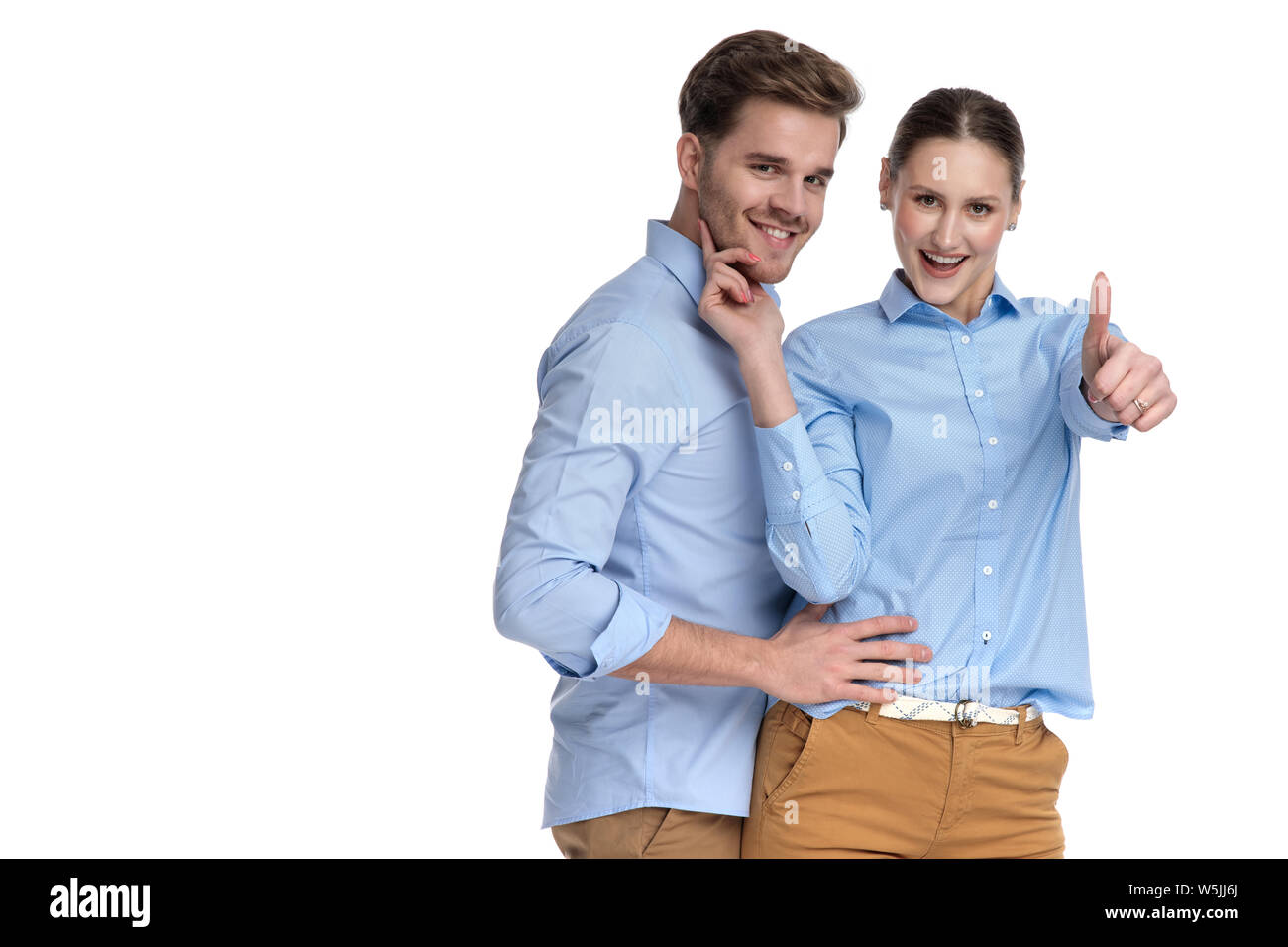 embraced happy casual couple, woman makes the ok sign on white ...