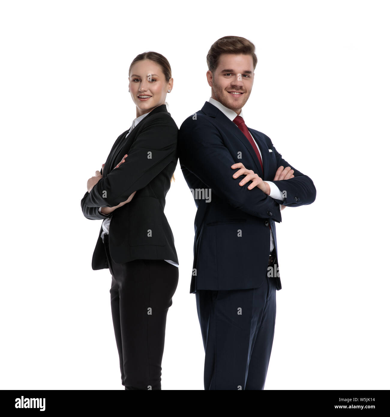 couple in business suits standing back to back with crossed arms on white background Stock Photo