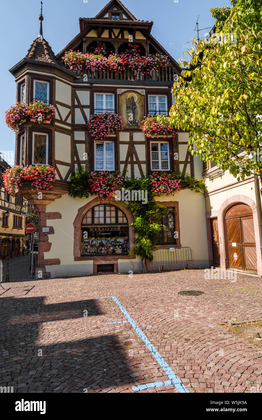 flower decorated facade of a half-timbered house in the old town of Kaysersberg, Alsace, France, touristy destination Stock Photo