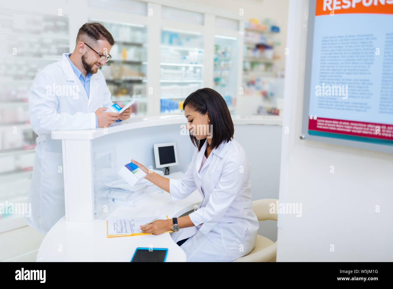 Attentive young chemist checking list of medicine Stock Photo