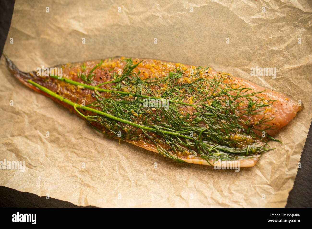 A single whole, raw mackerel fillet that has been used to make gravlax