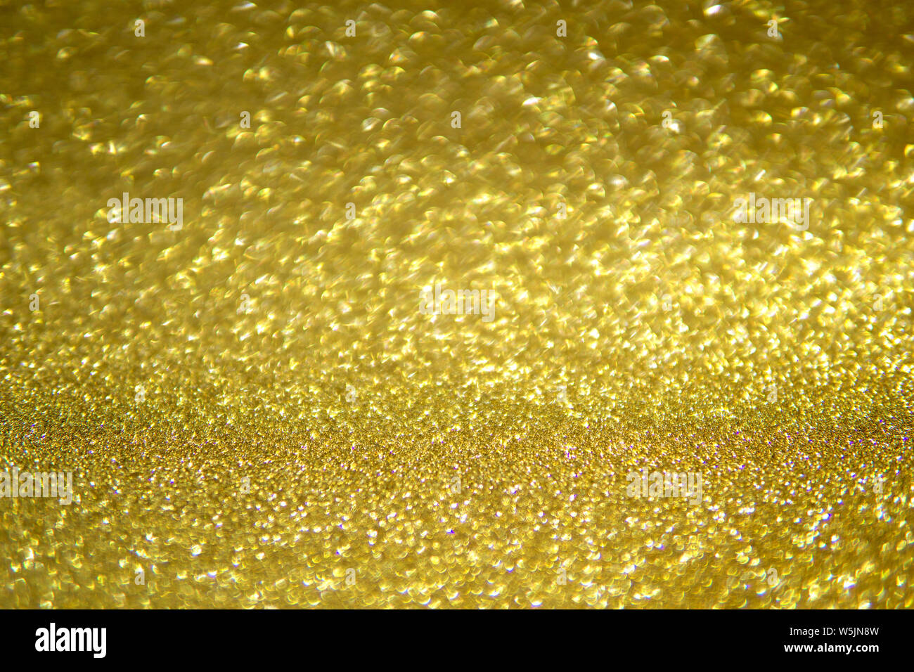 Abstract blurred background of golden glitter light partly in focus. Stock Photo