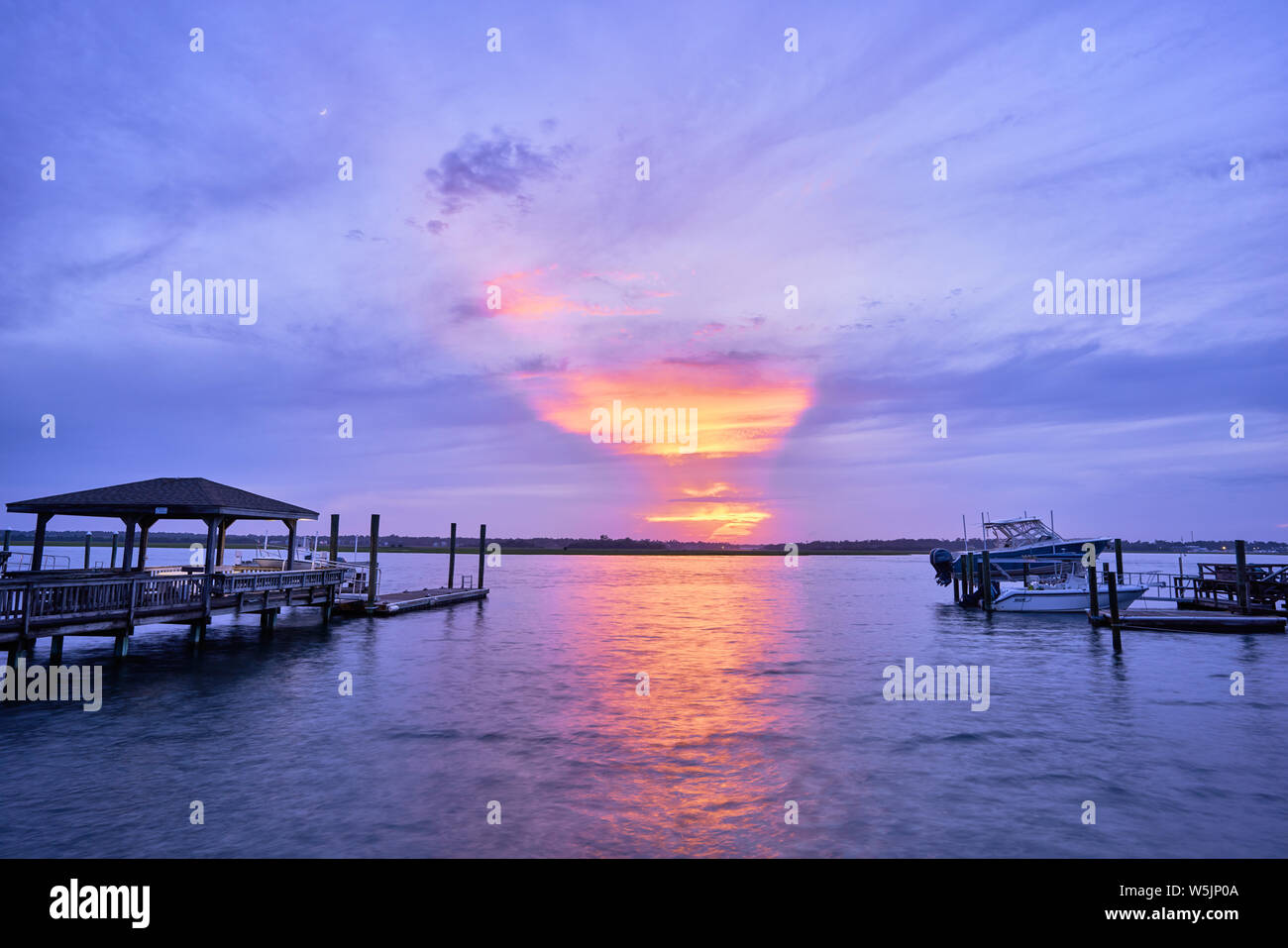 As the sunset fades the moon appears over Masonboro Inlet at ...