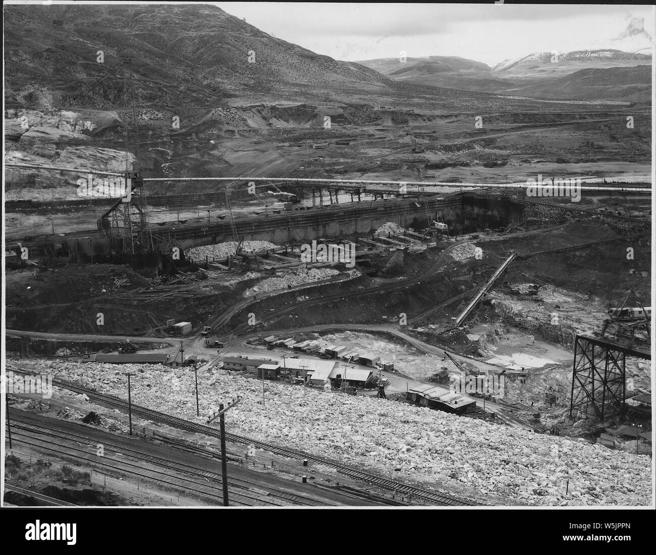 A downstream two-view progression picture showing the west bank area.; Scope and content:  Photograph from Volume Two of a series of photo albums documenting the construction of the Grand Coulee Dam and related work on the Columbia Basin Project. General notes:  This item and item 907 constitute a panoramic image. Stock Photo