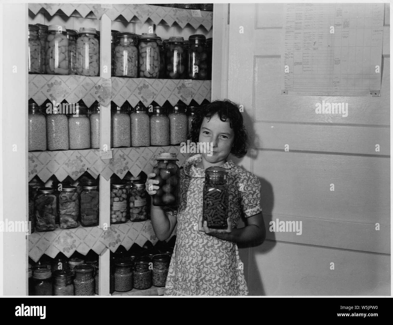 A girl holding two jars of canned goods Stock Photo Alamy