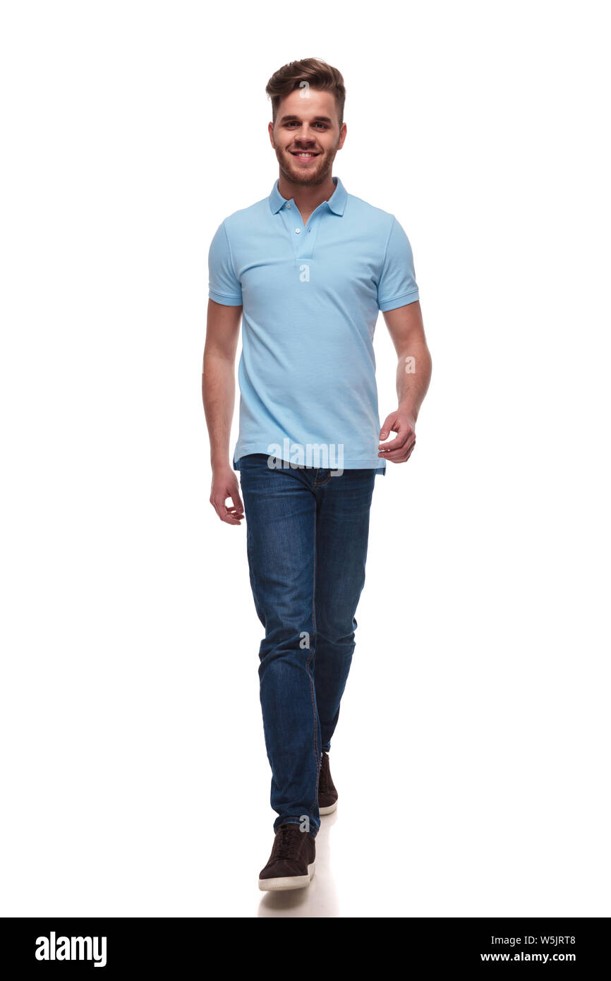 attractive casual man wearing blue polo tshirt steps forward on white