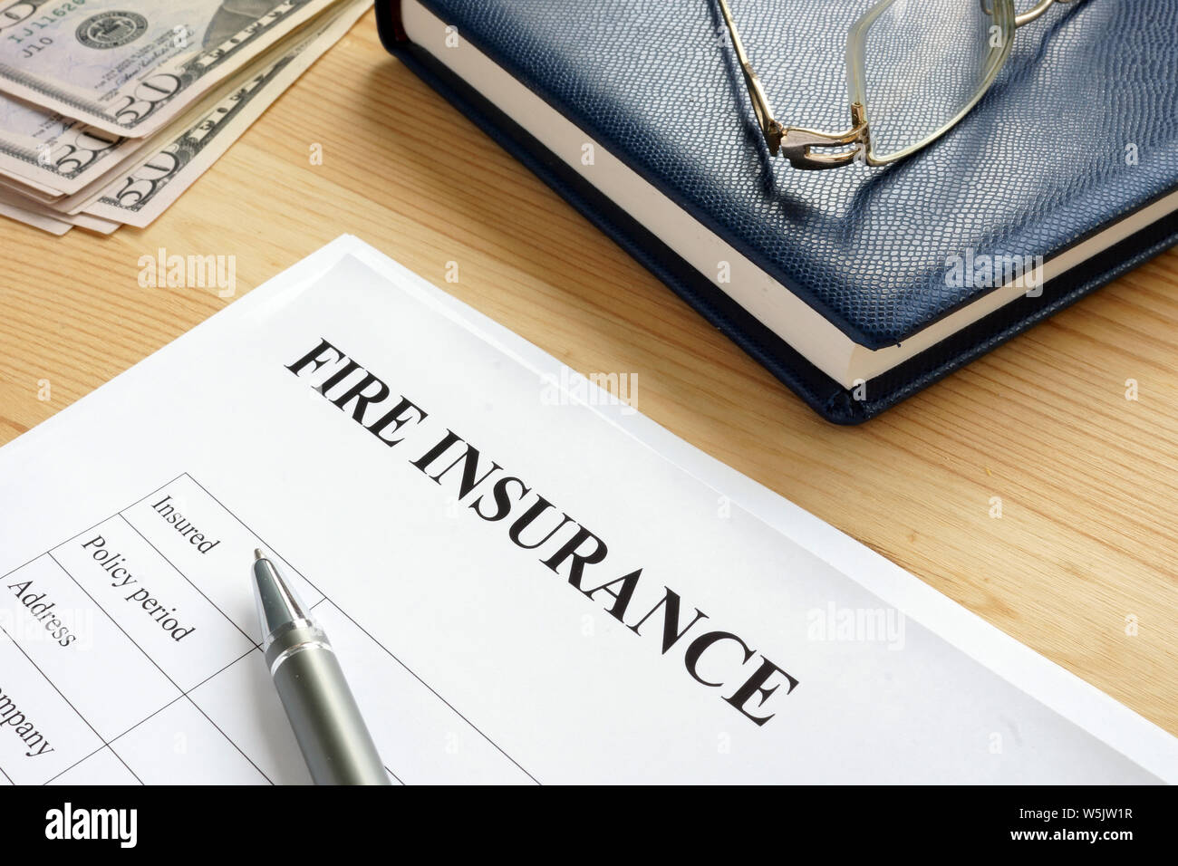 Fire insurance agreement with pen and money. Stock Photo