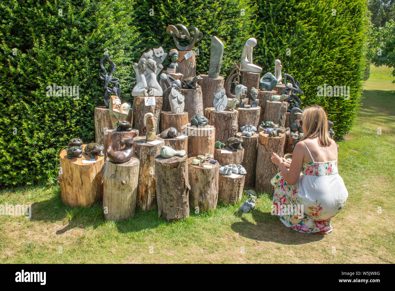 Display Of Garden Sculptures For Sale With A Woman Looking At Them