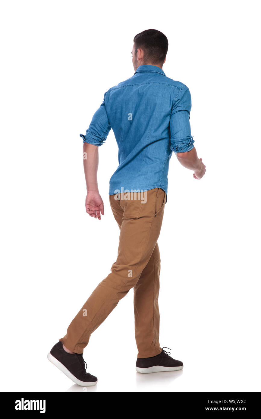 handsome casual man steps to side on white background and looks behind ...