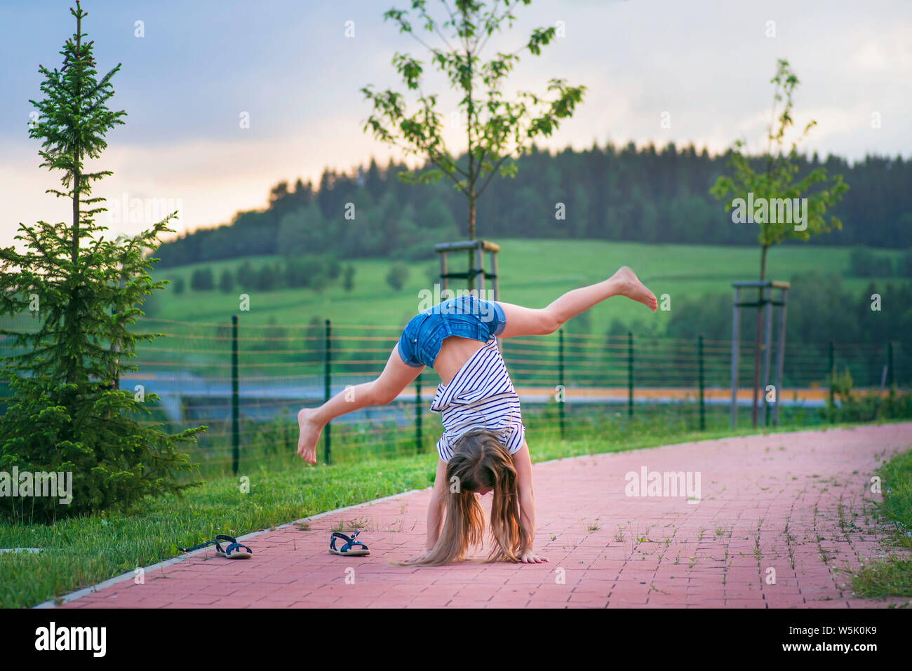 A girl does acrobatic stunts on the street.Girl acrobatics on the