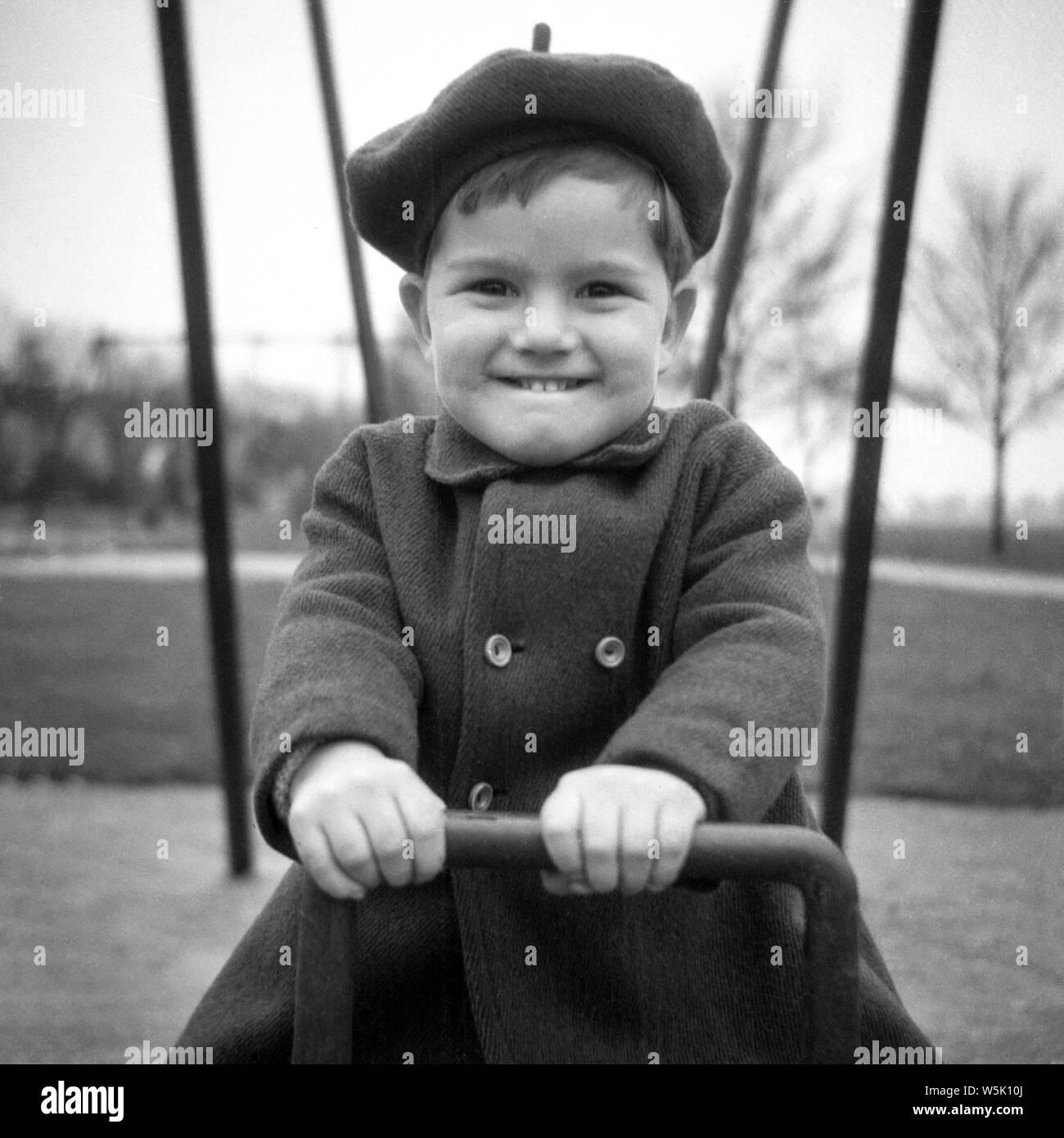 A young boy playing on the swings in Northampton in 1952 Stock Photo