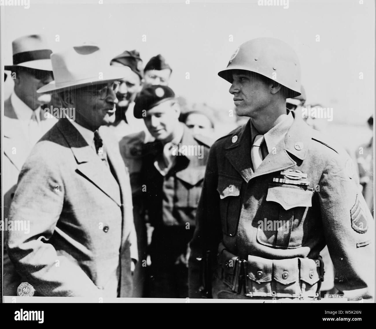 At an airfield near Brussels, Belgium President Harry S. Truman, en route to the Potsdam Conference in Germany, speaks to a member of the 137th Regiment of the 35th Division. The 35th Division was designated as honor guard because it was the President's outfit in World War I. The soldier speaking to the President is Staff Sgt. Ernie Atkin of Madisonvale, Tennessee. Stock Photo