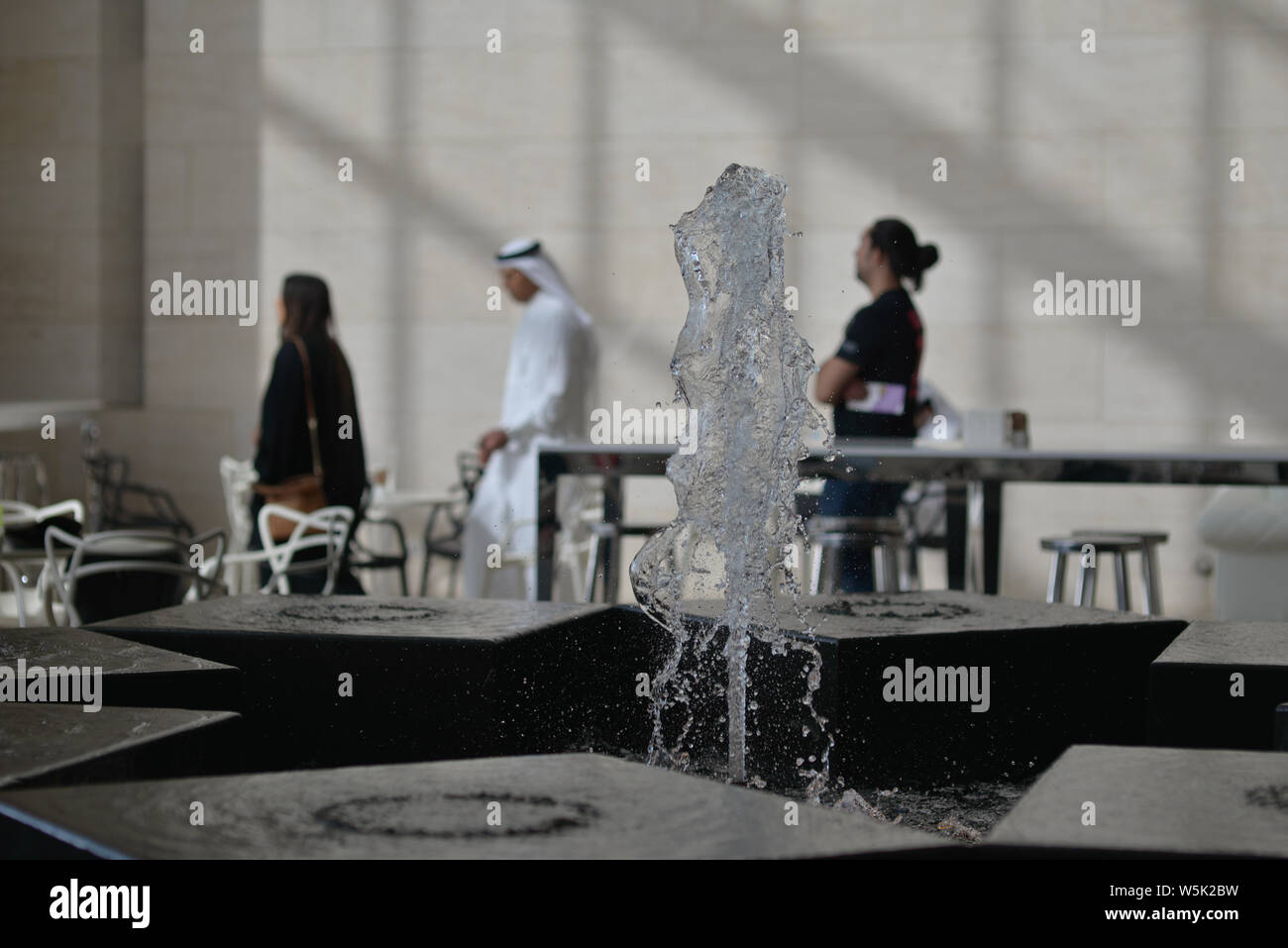 DOHA, QATAR - MAY 21, 2016:  Fountain and blurred background with a qatari couple at the Museum of islamic Art. Stock Photo