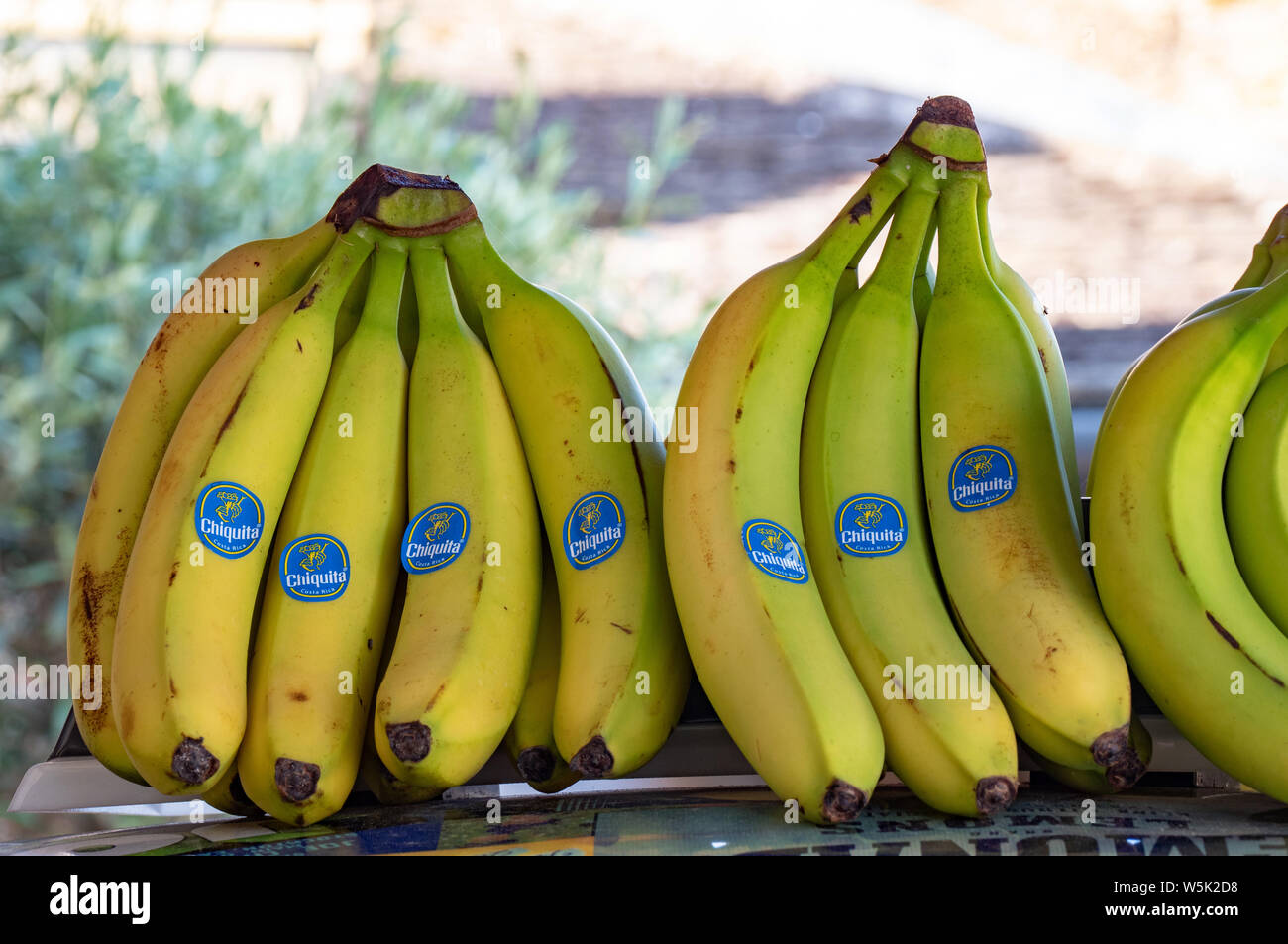 Bunches of Bananas for sale outside a shop in Broadway, Worcestershire, England, UK Stock Photo