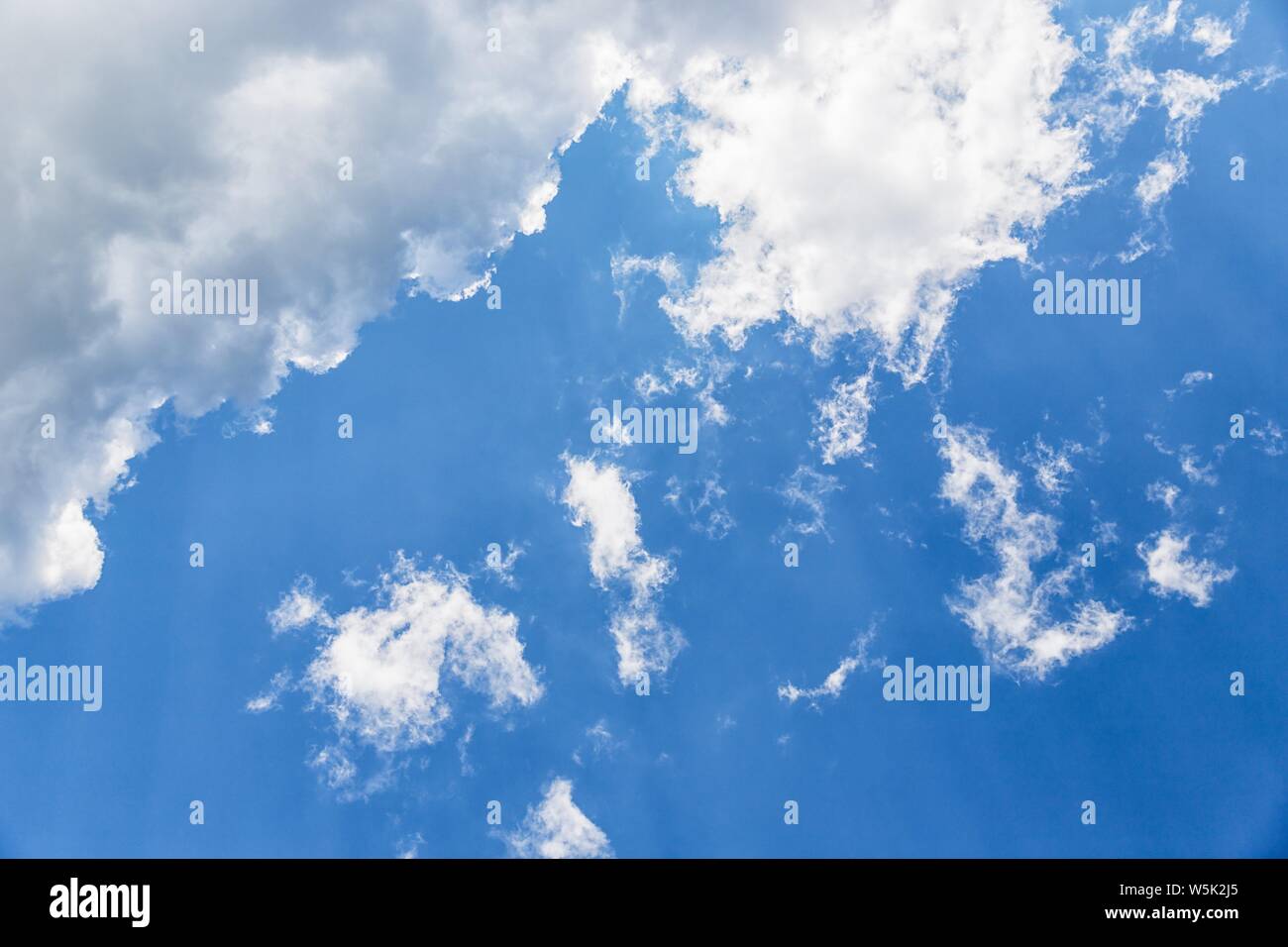 Beautiful white fluffy clouds on a deep blue sky background Stock Photo