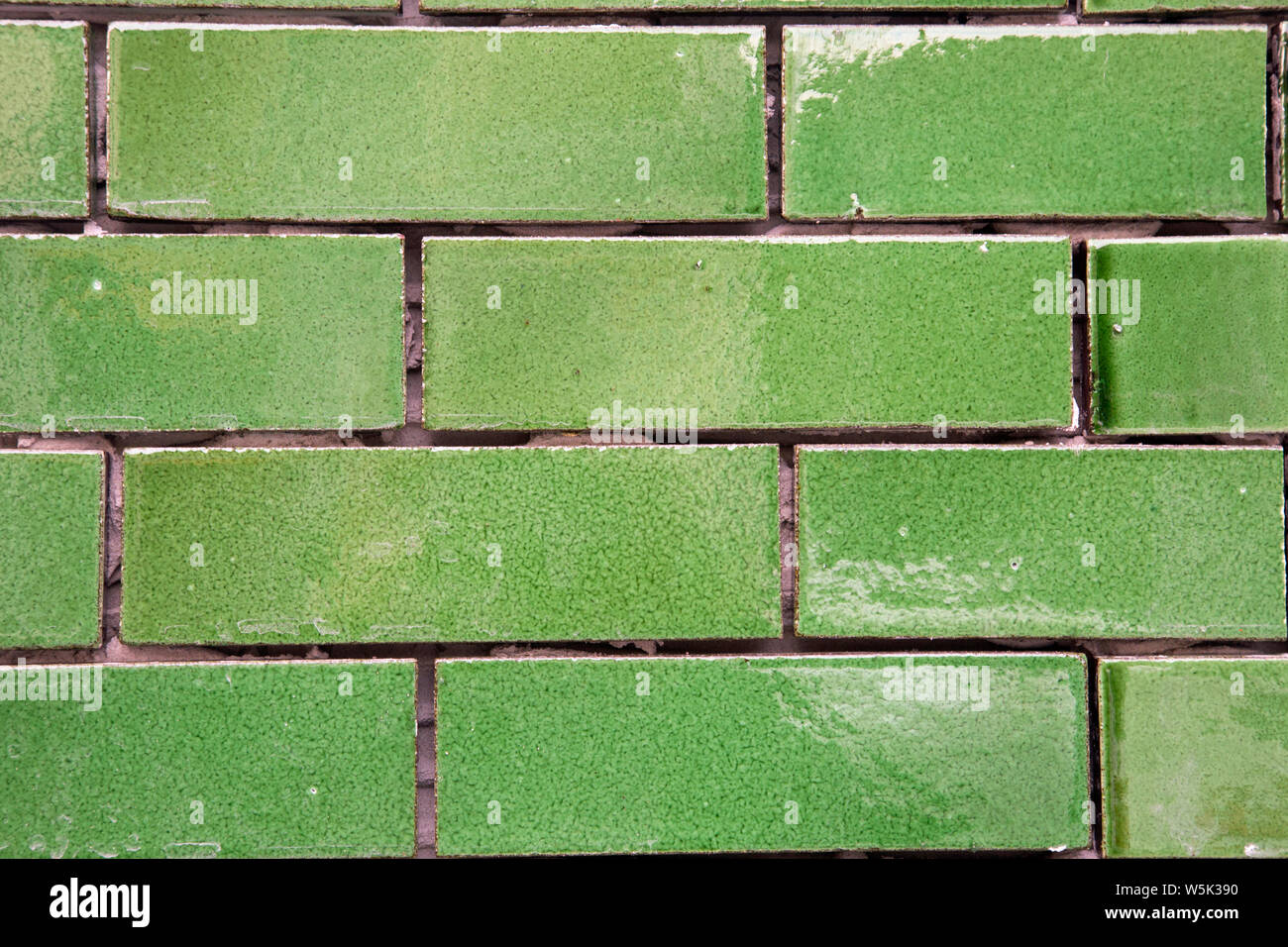 Green glazed brick tiles shot close as a landscape background Stock
