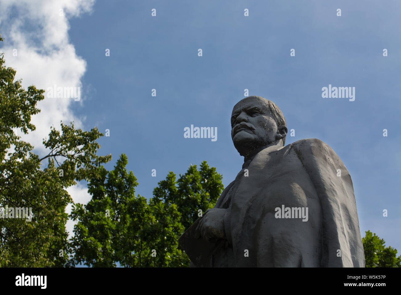 Low angle view of Vladimir Lenin statue against cloudy sky background Stock Photo