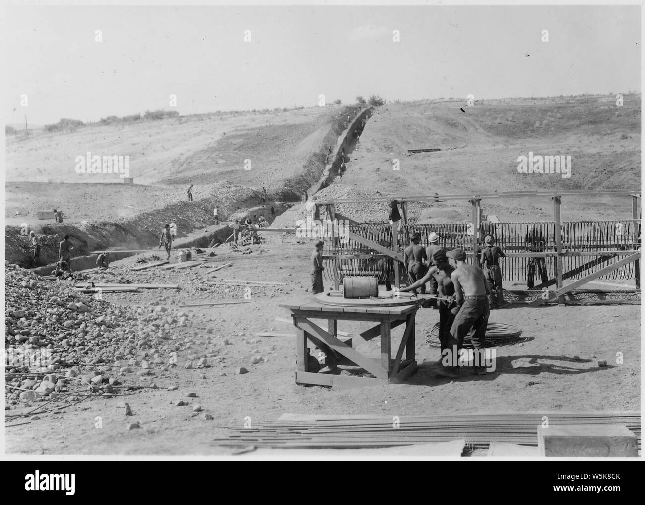 CCC Camp BR-66 Yakima-Tieton Project: Photo of the construction of 48 inch monolithic reinforced concrete siphon. Enrollees are bending hoops for siphon barrel reinforcement. J. S. Moore photographer Stock Photo