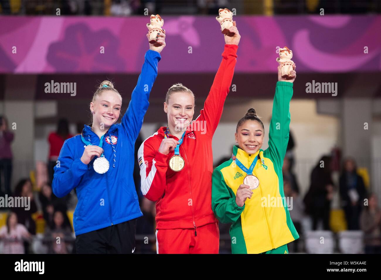 Lima, Peru. 29th July, 2019. Gold medalist Ellie Black of Canada is flanked by silver medalist Riley McCusker of United States and bronze medal winner Flavia Saraiva of Brazil saluting the crowd from the podium at the Pan American Games Artistic Gymnastics Women's All Around final at Polideportivo Villa el Salvador in Lima, Peru. Daniel Lea/CSM/Alamy Live News Stock Photo