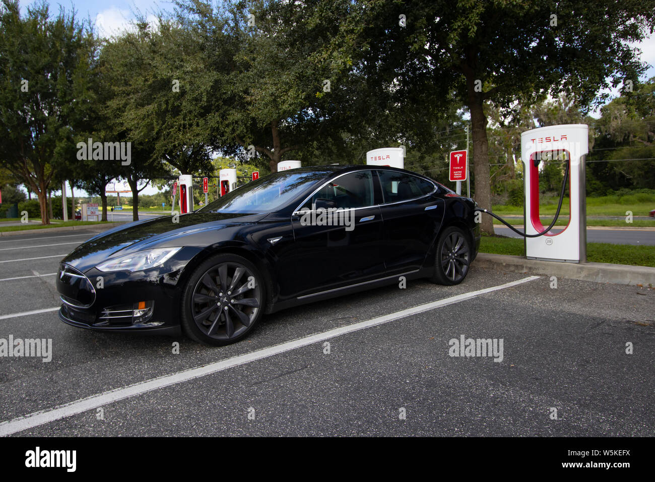 Tesla electric vehicle, a Tesla model S, at a Tesla charging station ...