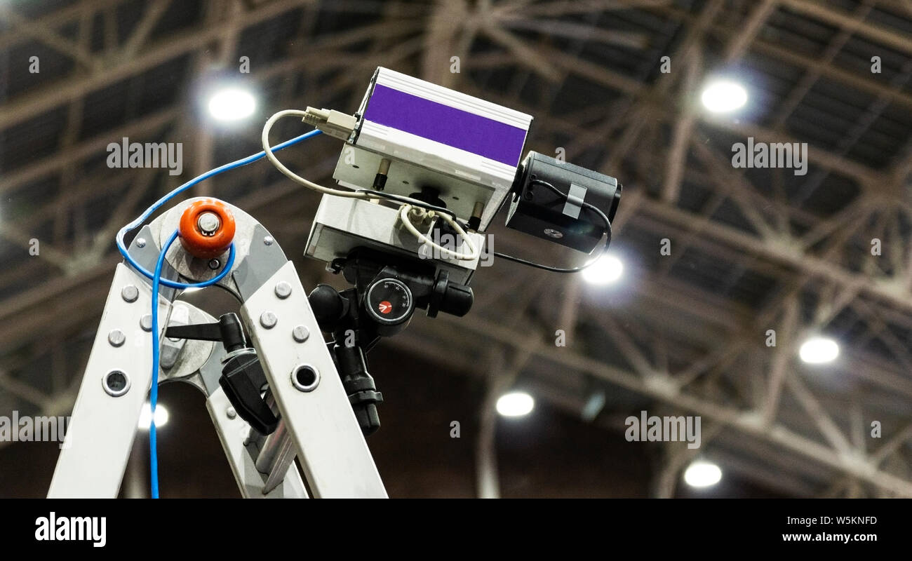 A fully automated timing system camera on a ladder in an indoor track and field center. Stock Photo