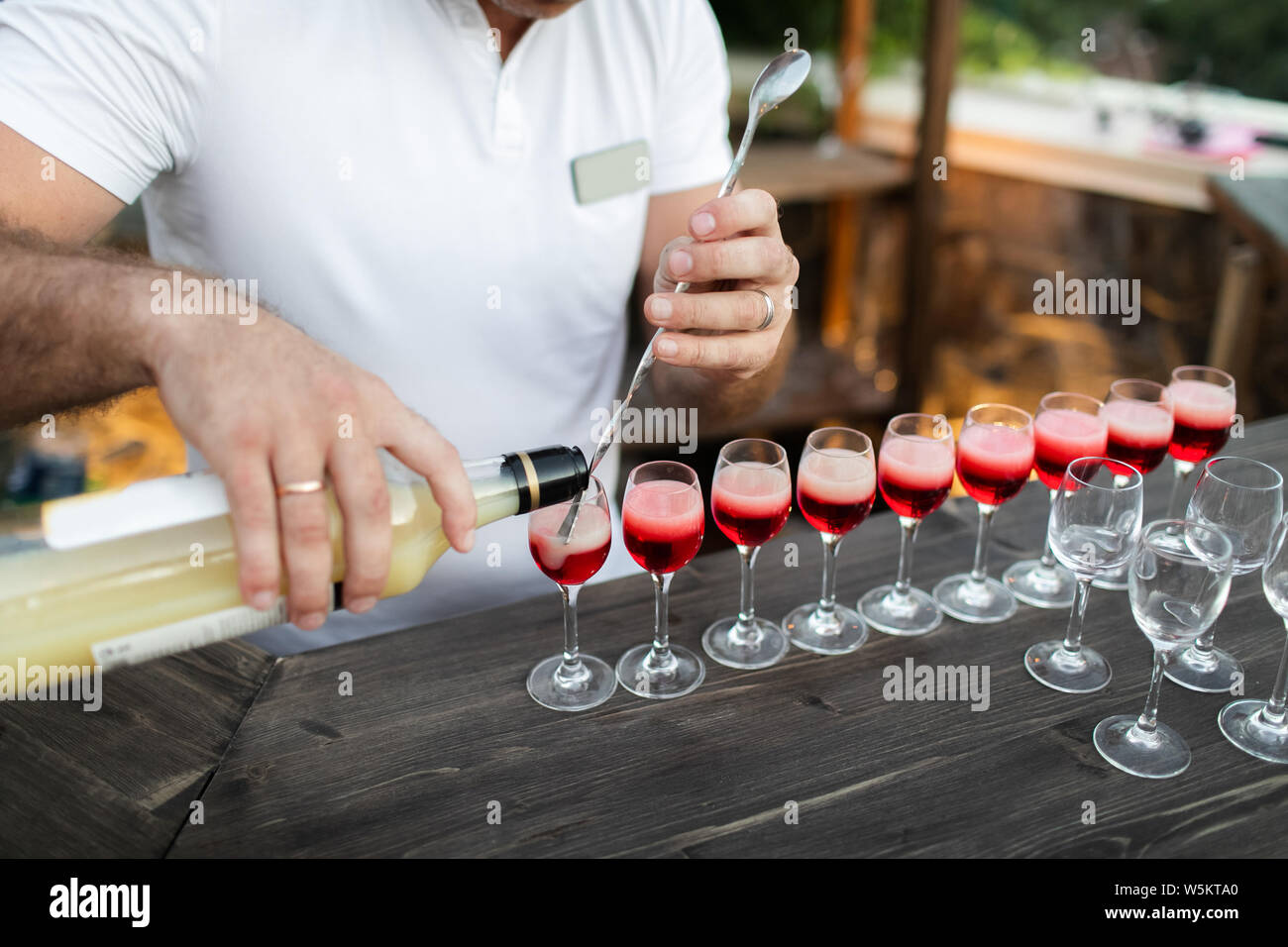 Bartender S Hands Pouring Alcohol Into The Cocktail Glasses Filled