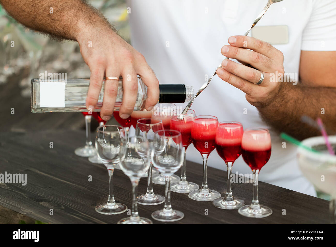 Bartender S Hands Pouring Alcohol Into The Cocktail Glasses Filled
