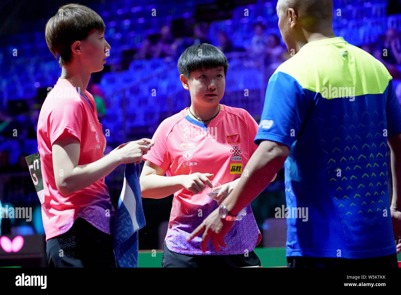 Sun Yingsha and Wang Manyu of China talk to their coach as they compete ...