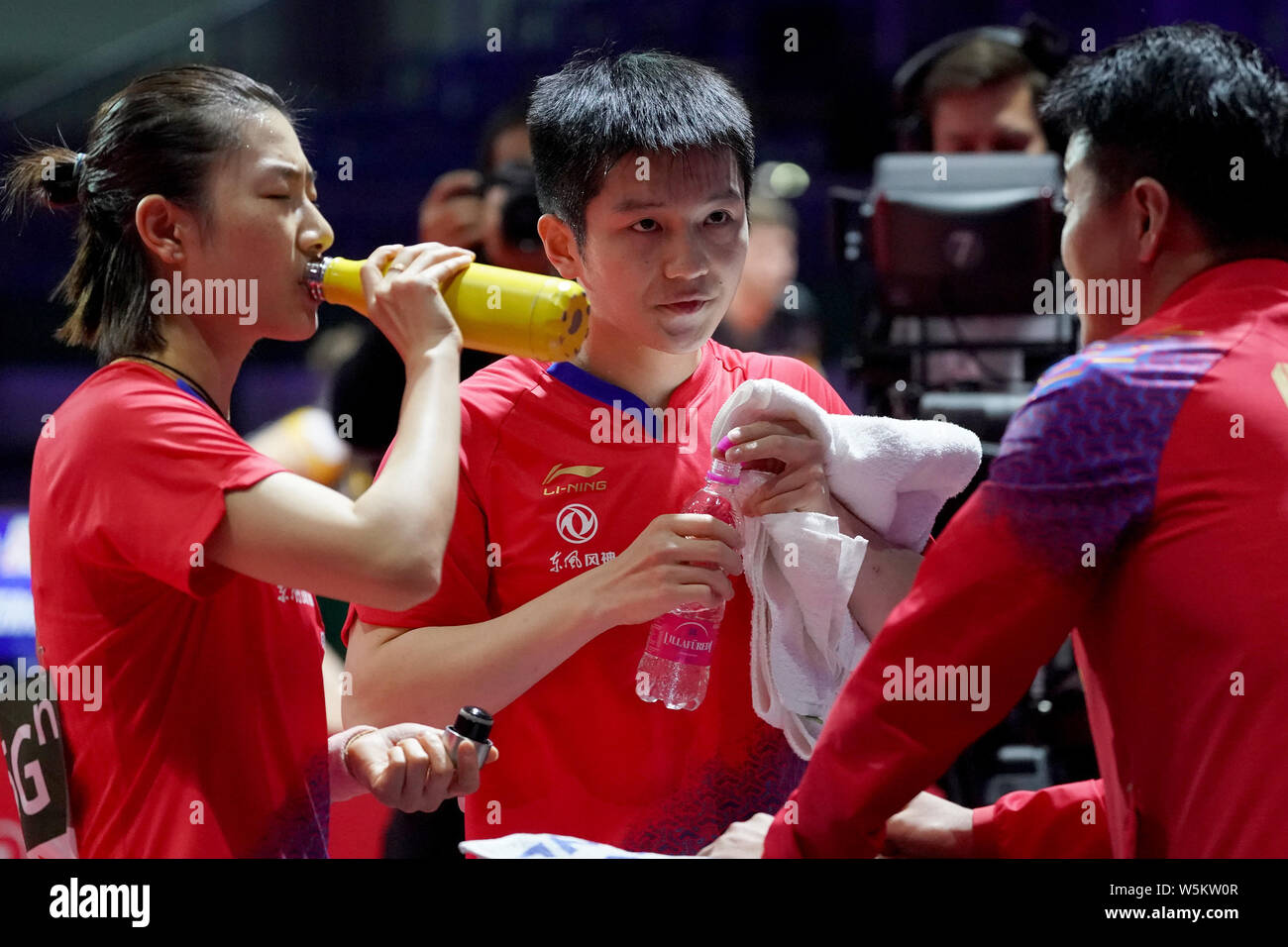 Fan Zhendong and Ding Ning of China talk to their coach Wang Hao as ...