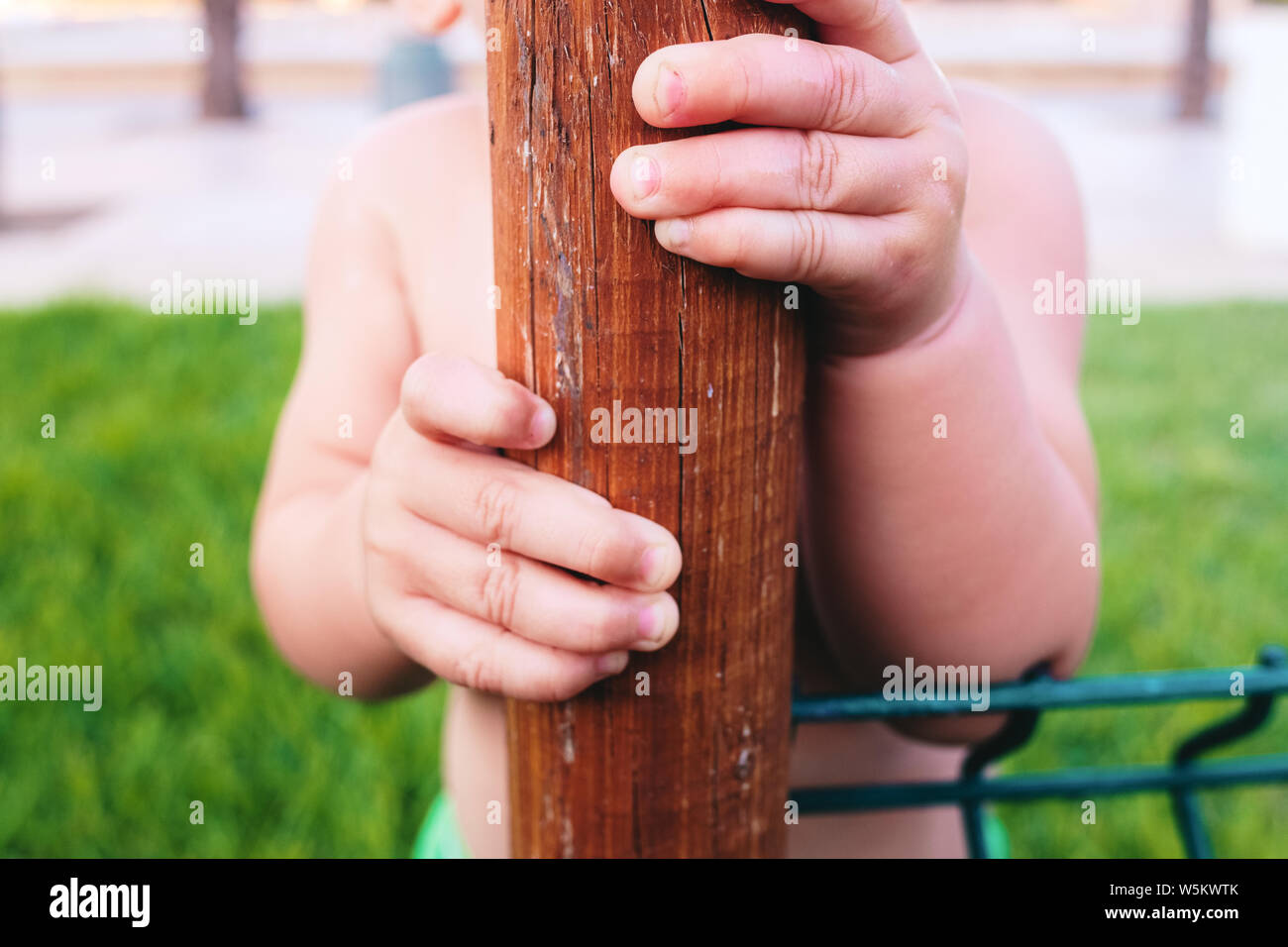 Close-up of a baby's hand clutching a trunk to support his learning to walk. Stock Photo