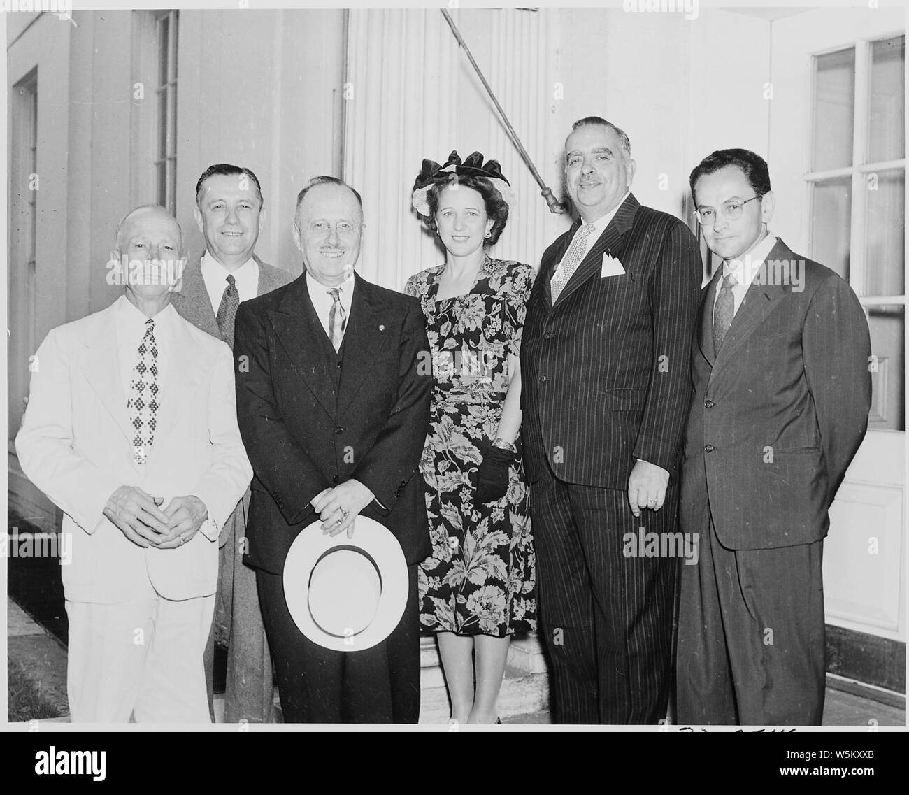 Delegation outside the White House attending the bill signing to make the governership of Puero Rico an elected office. L to R: Irving Silverman, Oscar Chapman, Isrin A. Fernus, unidentified lady, Jesus T. Pinero, and Fred Crawford. Stock Photo