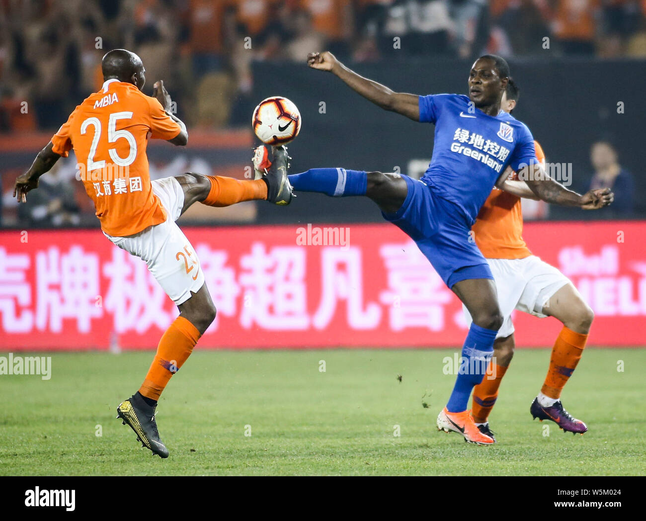 Nigerian football player Odion Ighalo, right, of Shanghai Greenland?Shenhua F.C. challenges Cameroonian football player Stephane Mbia Etoundi of Wuhan Stock Photo