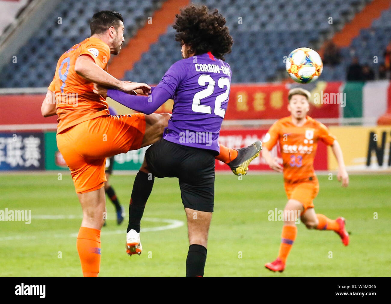 Italian football player Graziano Pelle, left, of China's Shandong Luneng Taishan F.C. passes the ball against a player of Malaysia's Johor Darul Ta'zi Stock Photo
