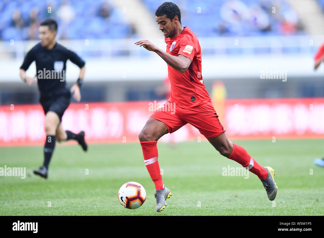Brazilian football player Alan Douglas Borges de Carvalho, simply known as Alan, of Tianjin Tianhai dribbles against Hebei China Fortune in their 4th Stock Photo