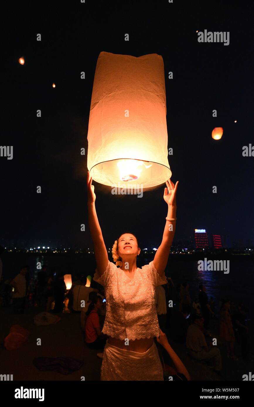 Tourists and people of Dai ethnic group release sky lanterns, also ...