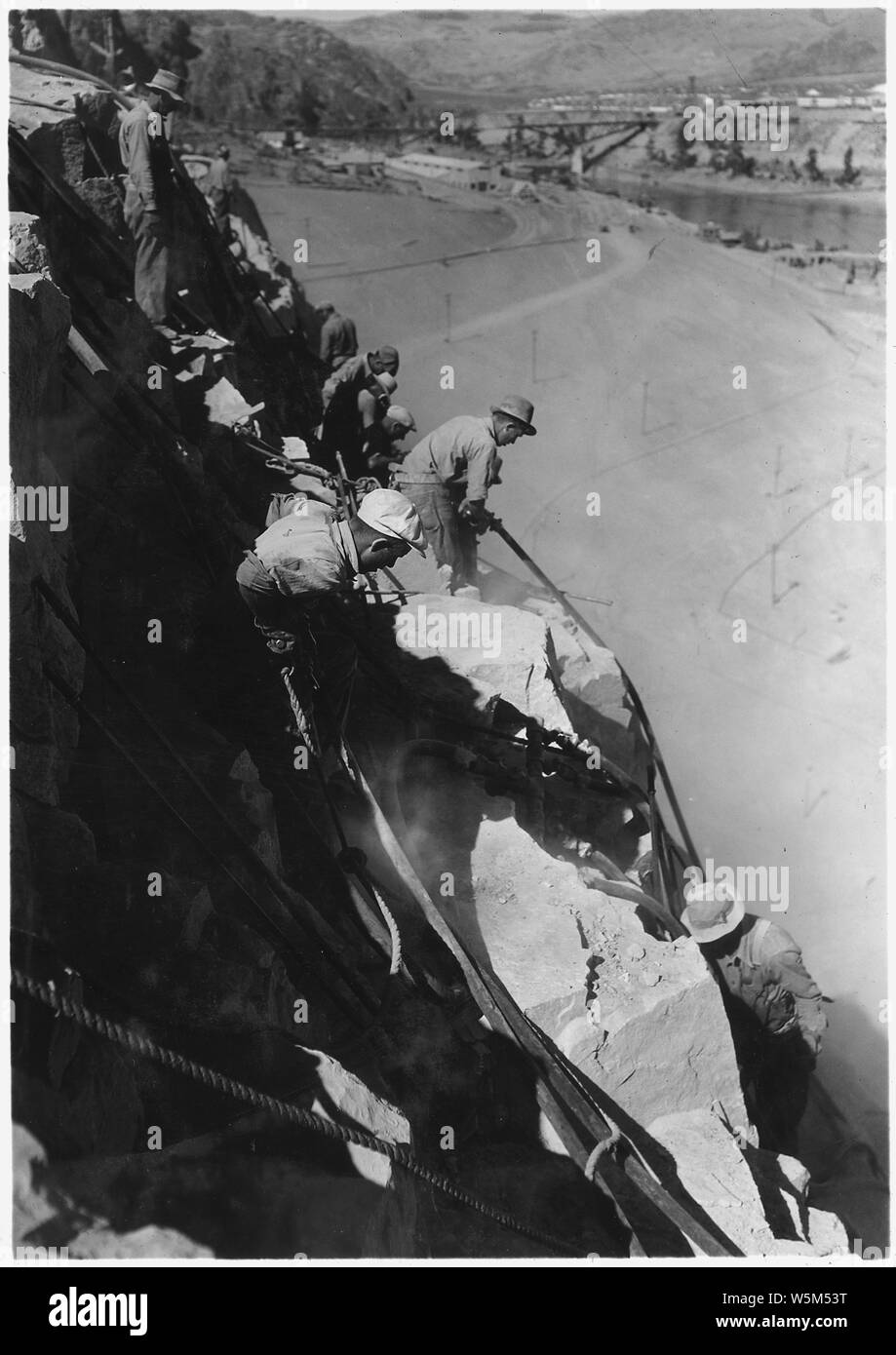 Drillers and scalers in west abutment.; Scope and content:  Photograph from Volume Two of a series of photo albums documenting the construction of the Grand Coulee Dam and related work on the Columbia Basin Project. Stock Photo