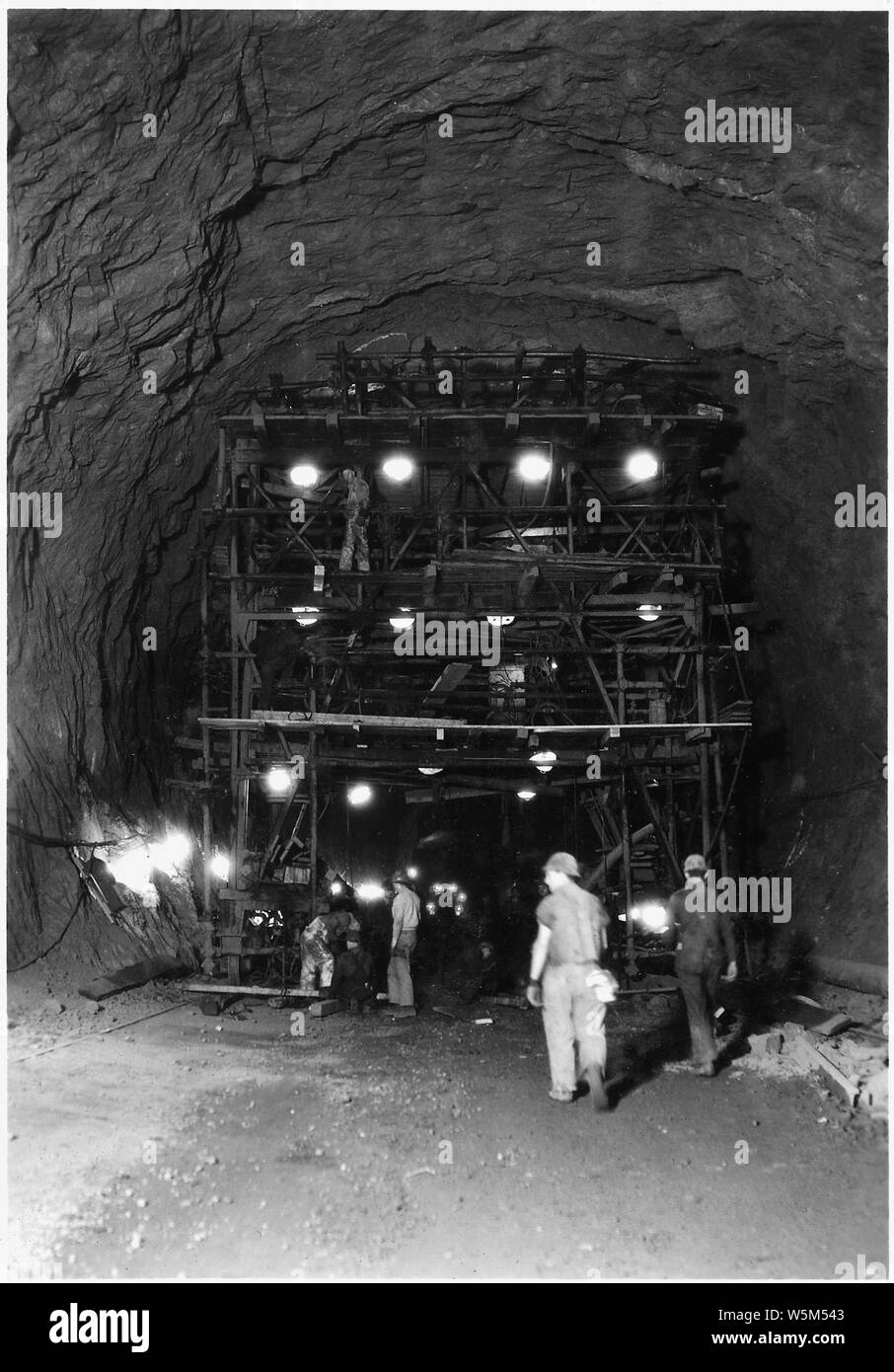 Drilling jumbo used in upper 36 feet of 41-foot diameter upper penstock header. This view shows the drilling face.; Scope and content:  Photograph from Volume Two of a series of photo albums documenting the construction of Hoover Dam, Boulder City, Nevada. Stock Photo