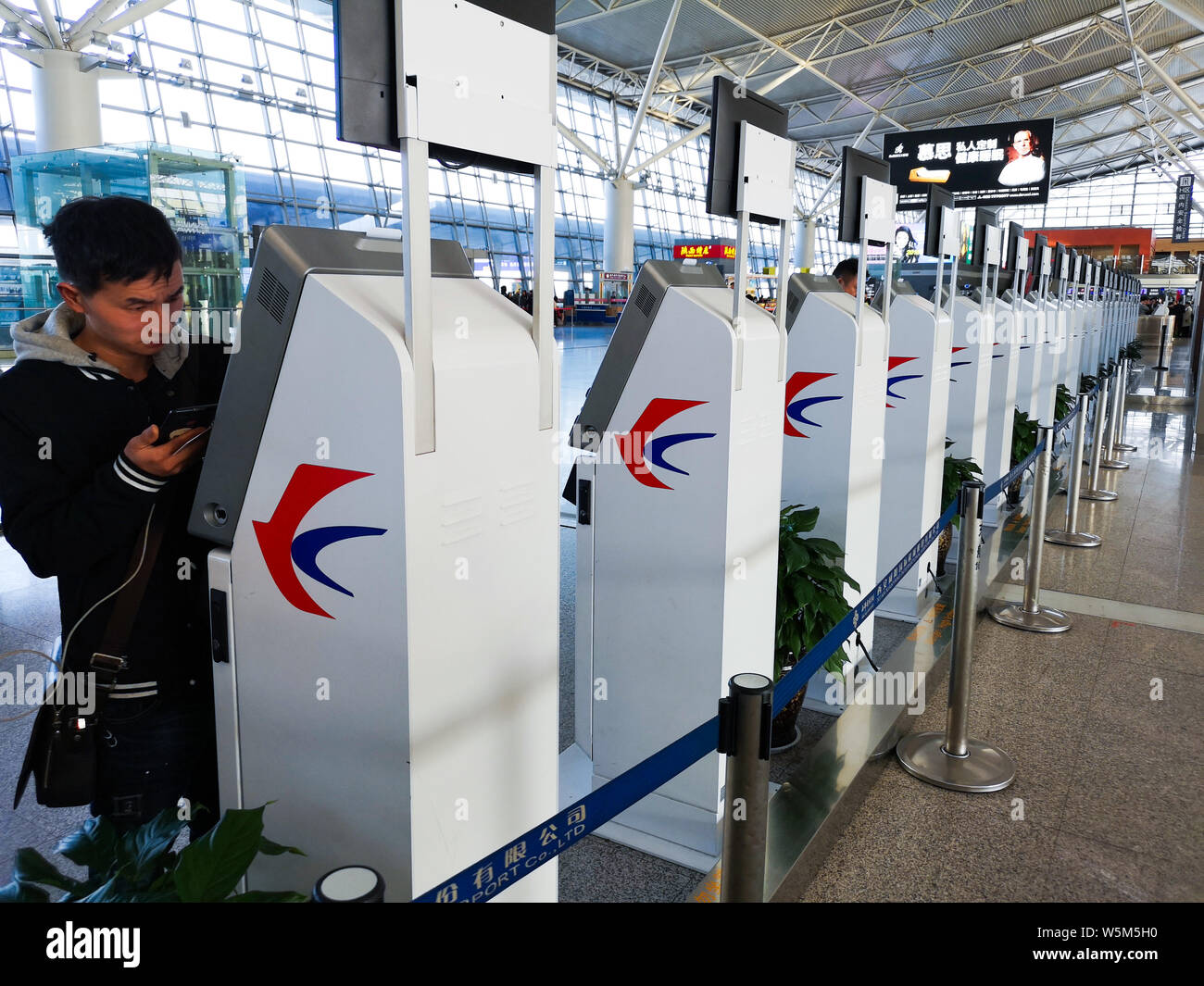 FILE--A passenger uses self-service electronic ticket check-in ...