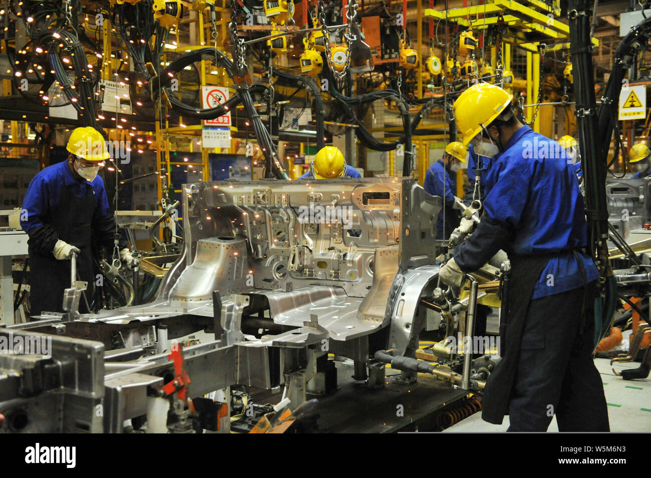 Chinese workers assemble cars on the assembly line at the auto plant of ...