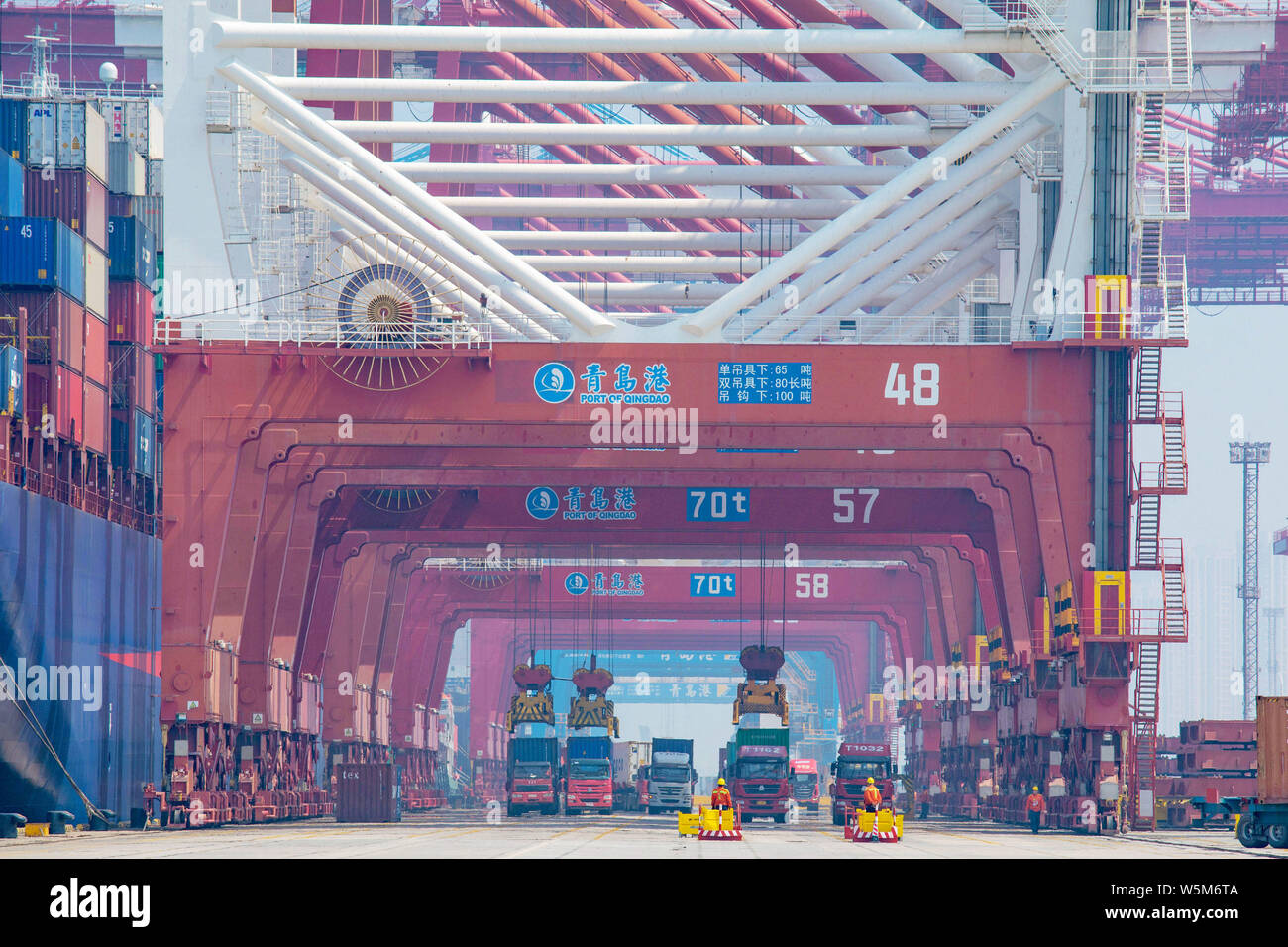 A crane vehicle lifts a container to be shipped abroad from a truck on ...