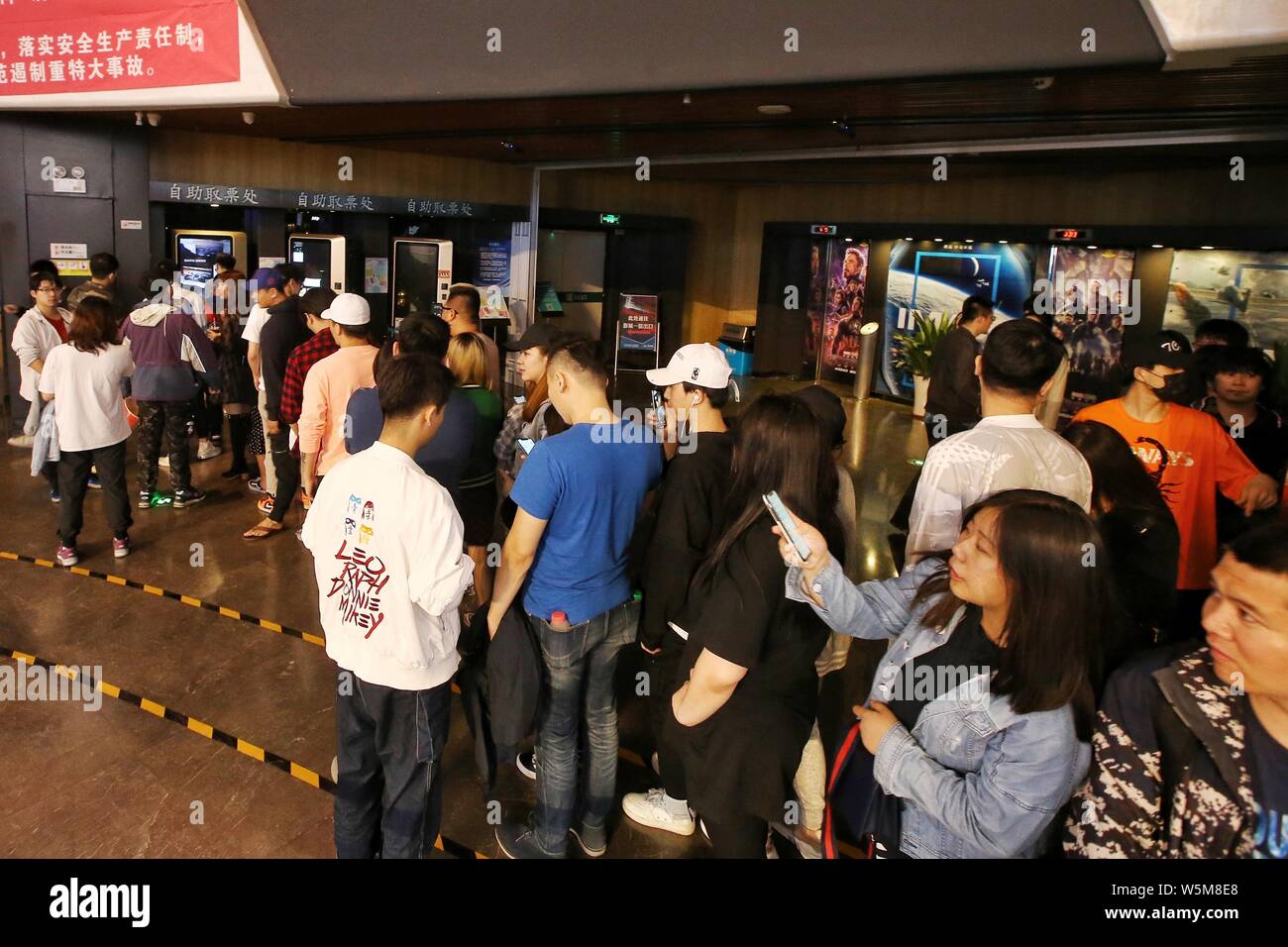 Chinese filmgoers queue up at a cinema before the midnight premiere of ...