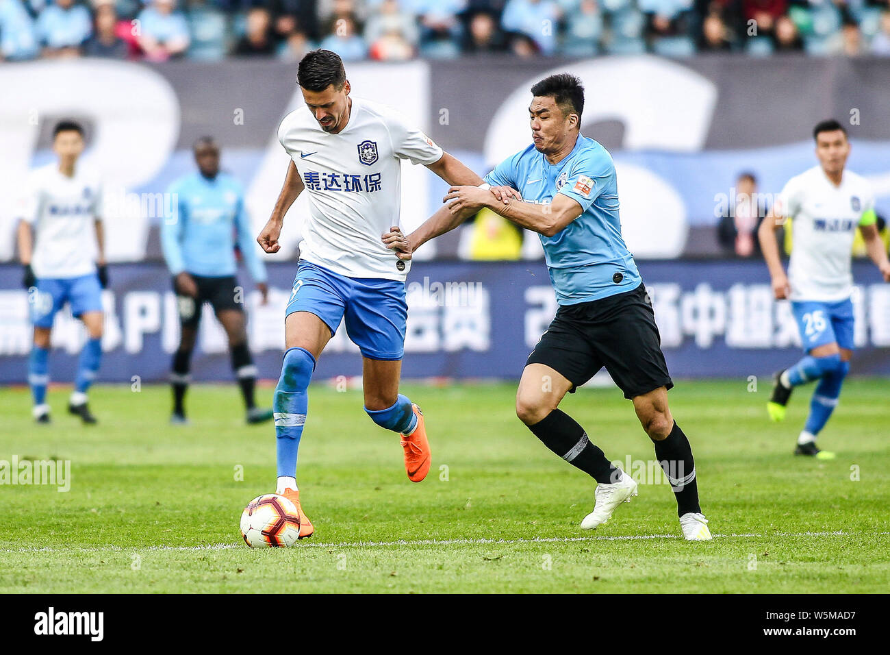 German football player Sandro Wagner, left, of Tianjin TEDA F.C. challenges Zhao Xuri of Dalian Yifang F.C. in their 4th round match during the 2019 C Stock Photo